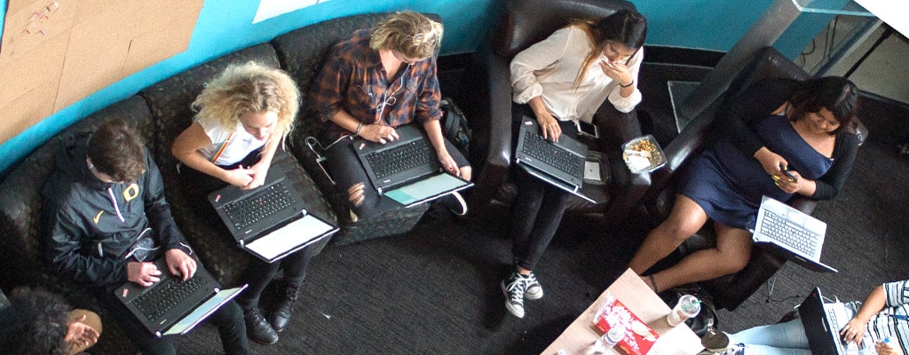 High-angle shot of students seated with laptops
